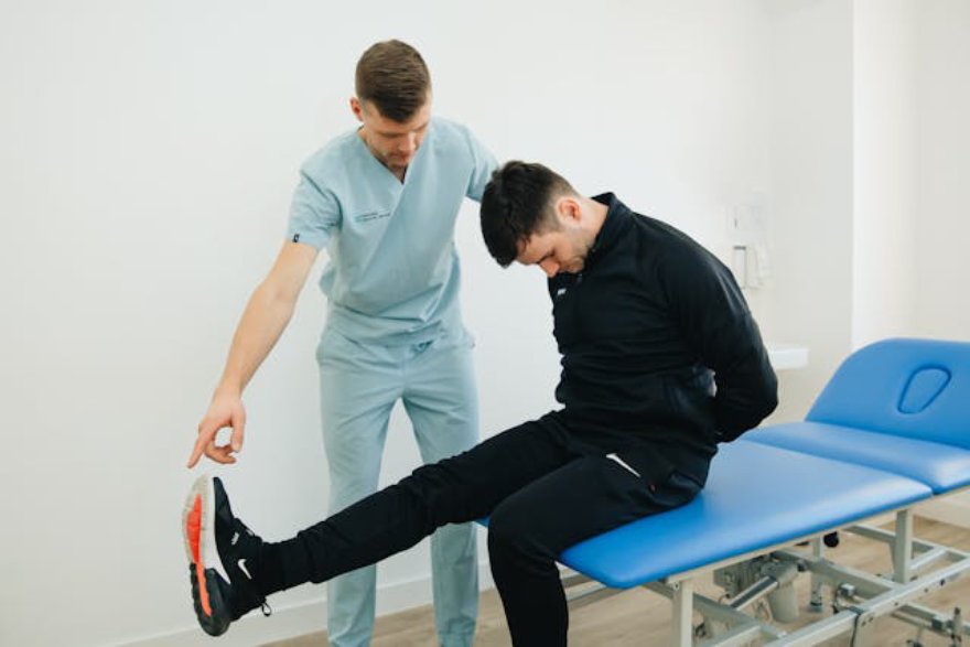 Čovek vežba na fizioterapiji sa doktorom