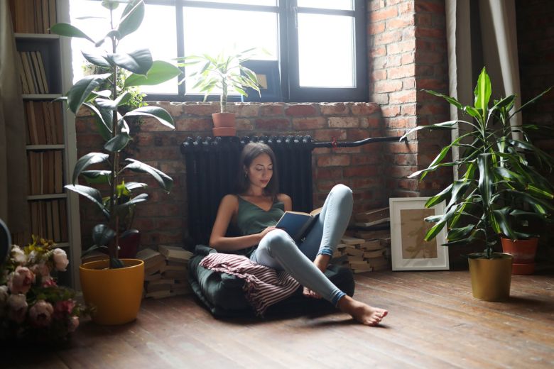 Žena sedi na podu u svom stanu.
